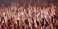 Una massa compatta di persone che si agita alzando le mani al cielo, sembrano come invocare un possibile aiuto proveniente da altrove