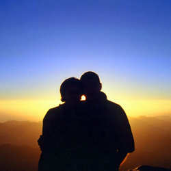 Immagine di una coppia in contemplazione al tramonto